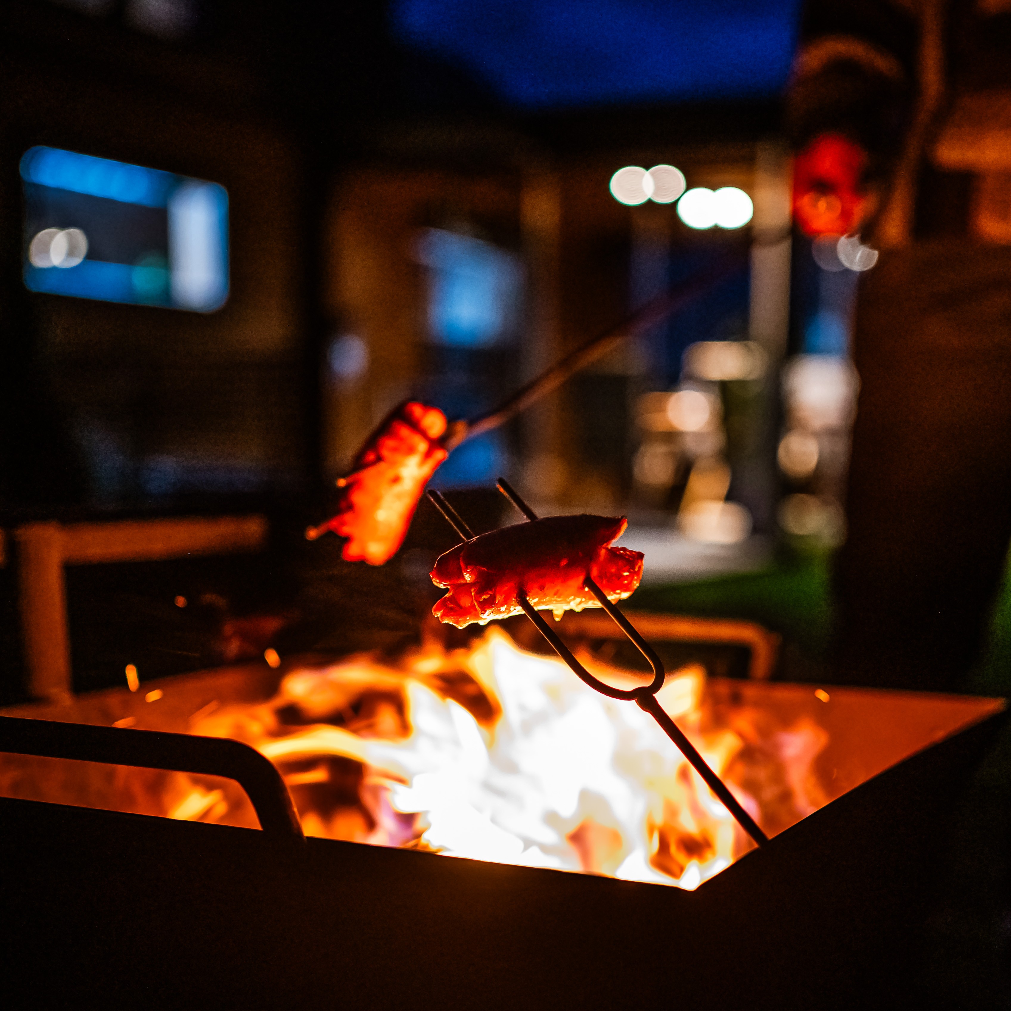 Sausages roasting over a campfire